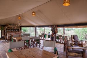 Kwa KuchiniaBaobab Tented Camp的帐篷内带桌椅的用餐室