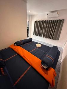 涛岛Divers House的一间卧室配有一张带橙色毯子的大床