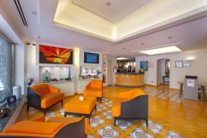索伦托德尔玛雷酒店的客厅配有橙色椅子,大堂