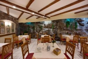 索伦托德尔玛雷酒店的一间带桌椅和石墙的餐厅
