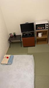 东京Bessalov Home Japanese style room的客房设有1张床、1台电视和1张桌子。