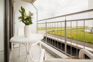 诺德奈Kaiserperle 114的阳台上的白色桌子和花瓶