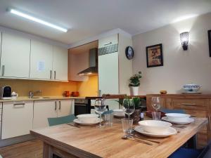 博尔德斯·代瓦里拉AC Apartaments Bordes的厨房配有木桌和餐具