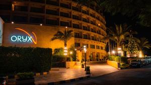 亚喀巴Oryx Hotel Aqaba的建筑一侧有标志的酒店
