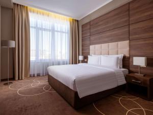 阿纳帕Movenpick Resort & SPA Anapa Miracleon的一间卧室设有一张大床和一个大窗户