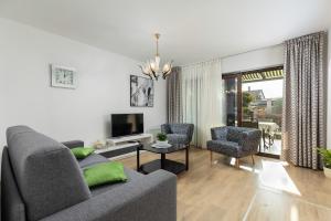 普拉Apartment VIVIANA的客厅配有沙发、两把椅子和电视