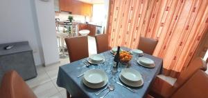 拉纳卡Vasilas Holiday Apartment #2的一张桌子,上面有蓝桌布和一碗水果