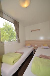 塞利讷Campsite Pisak - mobile homes by the sea的带窗户的客房内的两张床