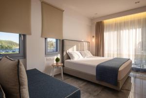 库佛斯港Notia Luxury Living的一间卧室配有一张床、一张沙发和窗户。