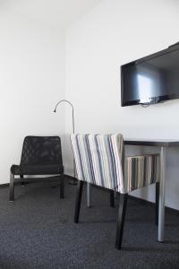 特隆赫姆布拉特拉P-酒店的客房设有一张桌子、一把椅子和一台电视。