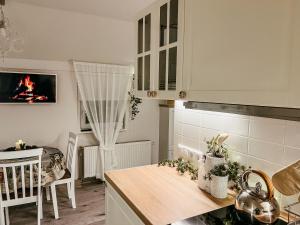 VaboleGuest house Laimes taure的厨房配有白色橱柜和带壁炉的桌子。