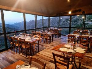 阿斯卡斯佩内亚旅馆的餐厅配有桌椅,位于山脉的背景中