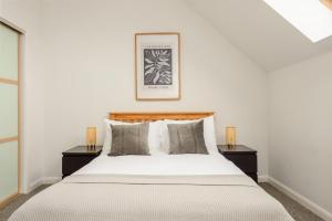 爱丁堡The Modern Mill Apartment的一间卧室配有一张带2个床头柜的大床