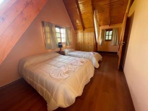 查斯科穆斯Náutico Apart Hotel的卧室设有2张床和木制天花板。