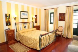 贝加德帕斯卡萨唐古斯曼宾馆的一间卧室配有一张床和一把椅子