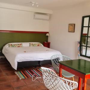 坦迪尔Clara en el Cerro的卧室配有一张床和一张桌子及椅子