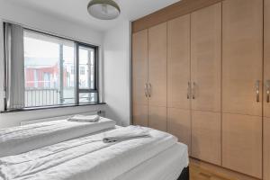 雷克雅未克Sunny Apartment - By the Sea in City Center的一间卧室设有两张床和窗户。