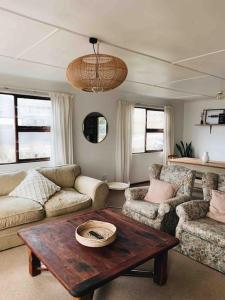 杰弗里湾Sweet & Simple Beach Cottage的客厅配有桌子、沙发和椅子