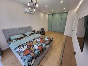 罗夫诺PRESTIGE-CENTER的一间卧室配有一张带五颜六色棉被的床