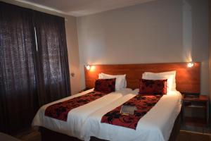 马塞卢Scenery Guesthouse Stadium的酒店客房设有两张床和大窗户。
