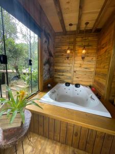 蒙特韦尔迪Recanto Lira II的木墙客房的按摩浴缸