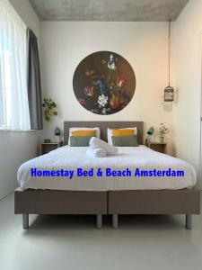 阿姆斯特丹Bed & Beach Amsterdam的卧室配有一张床,墙上挂有绘画作品