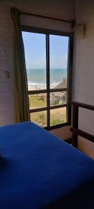 德尔迪阿布罗角安科拉酒店的一间卧室配有蓝色的床,享有海滩美景