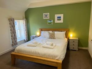 莫珀斯The Beresford Arms的绿色卧室,配有带毛巾的床