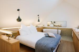苏黎世B2 Hotel Zürich的卧室配有一张白色大床和镜子