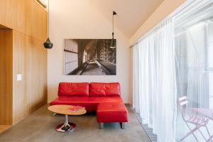 苏黎世B2 Hotel Zürich的客厅里一张红色的沙发,配有桌子