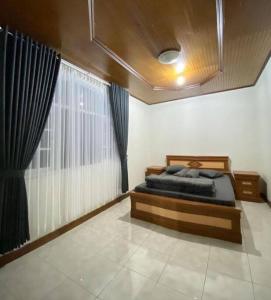 Villa Nada Situgunung.的一间卧室设有一张床和一个大窗户
