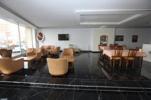 阿德亚曼Kommageneiz hotel的一间带桌椅和电视的用餐室