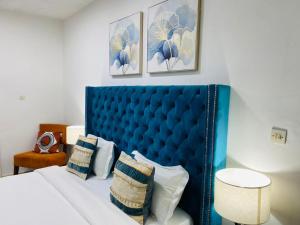 达喀尔ILLIYIN Boutique Hotel的卧室内的一张带枕头的蓝色床