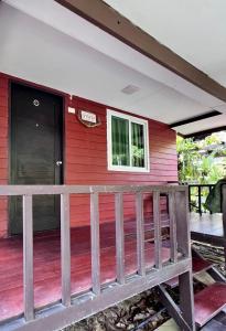 三帕兰MrT Riverside Sampran มิสเตอร์ที โฮมสเตย์-การเวก的红色的房子,设有木甲板