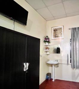 三帕兰MrT Riverside Sampran มิสเตอร์ที โฮมสเตย์-การเวก的浴室设有黑色的门和水槽。