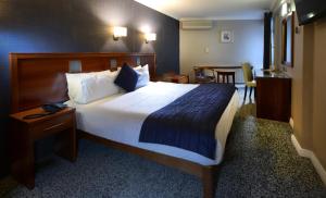 戈尔韦戈尔韦皇家酒店的酒店客房设有一张大床和一张桌子。