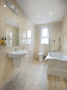 戈尔韦戈尔韦皇家酒店的一间带两个盥洗盆、浴缸和卫生间的浴室