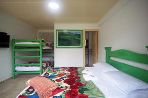 萨兰托Hotel Casa Quinta Salento的一间卧室配有一张带绿色床头板和鲜花的床。