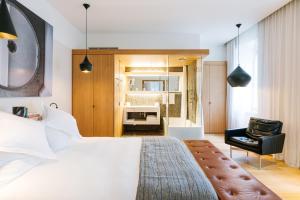 苏黎世B2 Hotel Zürich的卧室配有一张白色大床和一把椅子