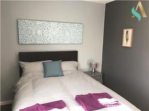 比林汉姆South View TSAC的一间卧室配有一张带紫色和蓝色枕头的床
