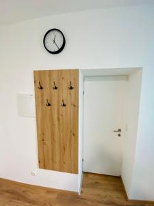 巴德伊舍Einzimmer-Apartment 25 m2 Gartenzinken im Zentrum von Bad Ischl的墙上有一扇门和一个钟的房间