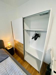 巴德伊舍Einzimmer-Apartment 25 m2 Gartenzinken im Zentrum von Bad Ischl的卧室内的玻璃冰箱,配有床