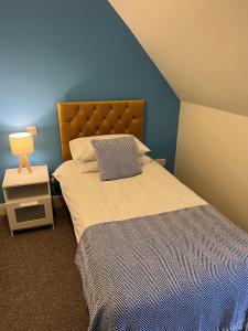 CorrieThe Corrie Hotel的一间卧室配有一张蓝色墙壁的床