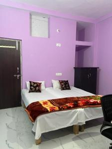 巴特那Riru girlstay的一间卧室设有紫色的墙壁和一张大床