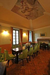 莱泽诺Palazzo Del Vicerè的一间带桌子和绿色椅子的用餐室