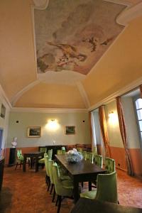 莱泽诺Palazzo Del Vicerè的一间带桌椅的用餐室和天花板上的绘画