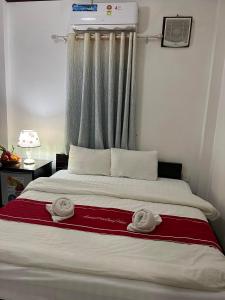 琅勃拉邦Jasmine Place House的一间卧室配有一张床,上面有两条毛巾