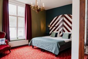 BabberichLandgoed Halsaf的一间卧室配有一张床、一把椅子和一个吊灯。