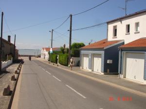 沙特拉永普拉日L' Ecume de Mer的一条空荡荡的街道,有房子,有骑摩托车的人