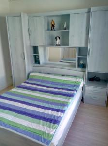 沙特拉永普拉日L' Ecume de Mer的一间卧室配有带条纹毯子的床